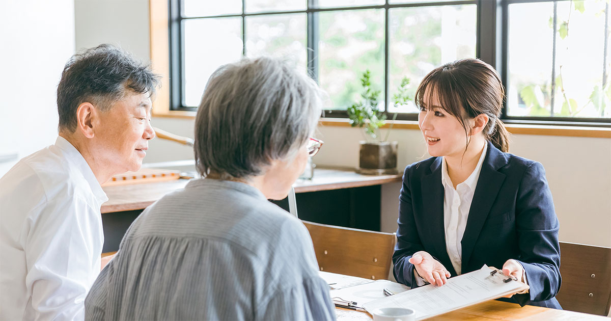 葬儀社スタッフと相談者が資料を見ながら話し合っている様子